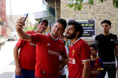 Iraqi footballer Hussein Ali, who plays for the Iraqi Al-Zawraa FC and is a lookalike of Liverpool's Egyptian forward Mohamed Salah, poses for pictures in the capital Baghdad, on June 4, 2018. With his black beard, curly hair and football shirt, Iraqi striker Hussein Ali is often mistaken for one of the world's top players: Egypt's Mohamed Salah. / AFP / SABAH ARAR