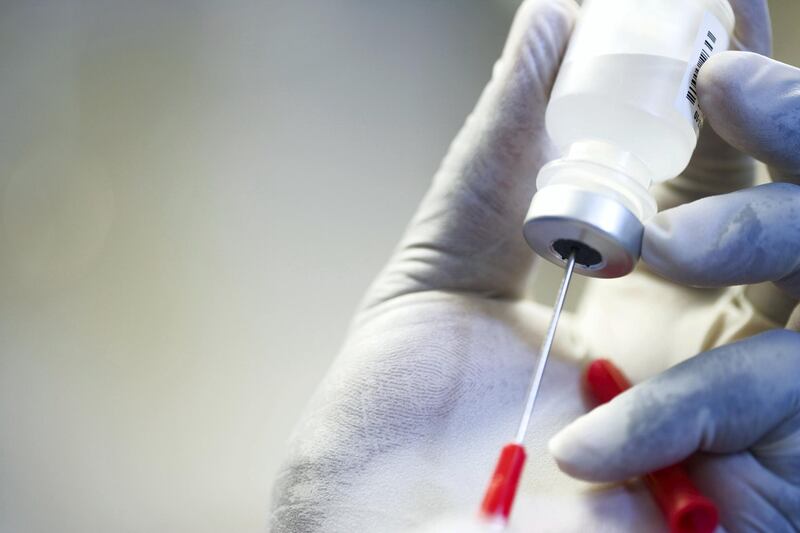 Close up of hand in rubber glove filling syringe