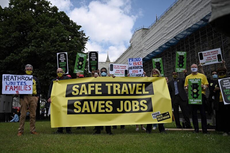 Demonstrators hold a banner with the slogan 'Safe Travel Saves Jobs' outside the Houses of Parliament. AFP