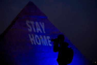 A general view of the Giza pyramid lit up with text encouraging Egyptians to stay home to limit the spread of the the Covid-19 coronavirus, during World Heritage Day, in Giza, Egypt, April 18, 2020. EPA