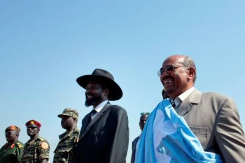 Sudanese President Omar al-Bashir (R) is welcomed by southern leader Salva Kiir (C) at Juba International airport on January 4, 2010. Southerners are set to vote in a referendum on January 9 on whether to remain united with the north or break away and form their own country and the president told them in a speech in the southern capital that he would celebrate the result of this week's referendum on southern independence, "even if you choose secession."AFP PHOTO/YASUYOSHI CHIBA