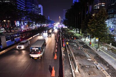 This picture taken on July 12, 2018 shows Indonesian labourers working on construction along Sudirman street in Jakarta, ahead of the 2018 Asian Games. Asian Games venues will be ready before Indonesia hosts the showpiece event in a month, organisers say, but the threat of terror attacks and endless traffic jams still looms over the regional Olympics. - TO GO WITH Indonesia-Asiad2018,FOCUS by Kiki SIREGAR
 / AFP / ADEK BERRY / TO GO WITH Indonesia-Asiad2018,FOCUS by Kiki SIREGAR
