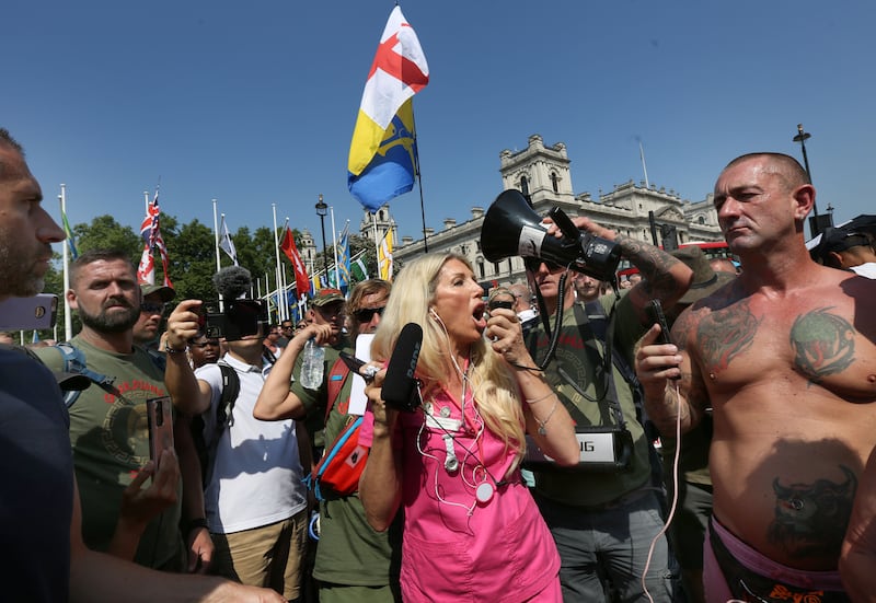 Kate Shemirani addresses protesters through a megaphone in Parliament Square as part of the protest.