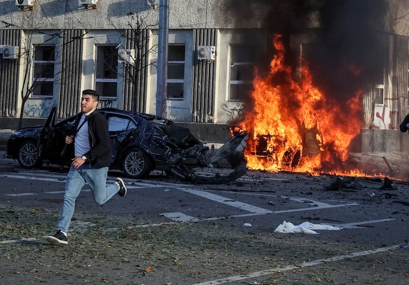 A man runs past a burning car in Kyiv. Reuters