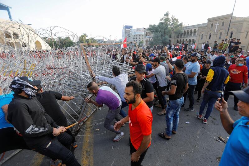 Demonstrators try to remove the fence. Reuters