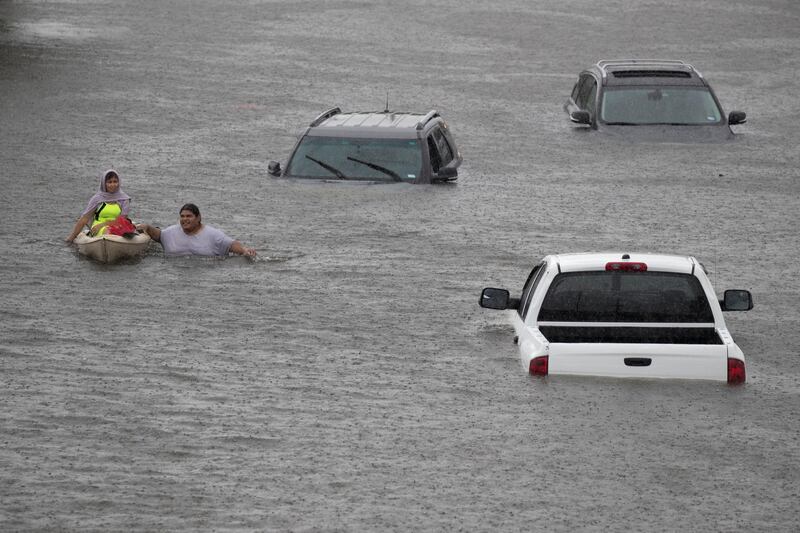 Jesus Rodriguez rescues Gloria Garcia after rain from Hurricane Harvey. At least two people were killed and 14 injured in the flooding. Adrees Latif / Reuters