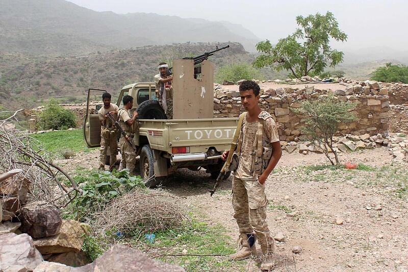 A Yemeni pro-government fighter poses in front of an armed pick-up.