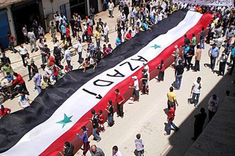 Protesters in the Kurdish city of Qamishli in northern Syria carry a huge national flag during a pro-democracy demonstration in May last year. The word written on the flag is Kurdish for “freedom”.