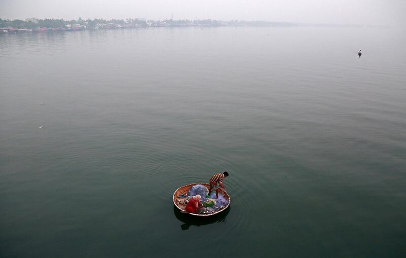 A fisherman and his wife catch fish in the waters of Vembanad Lake in Kochi, India. Sivaram V / Reuters