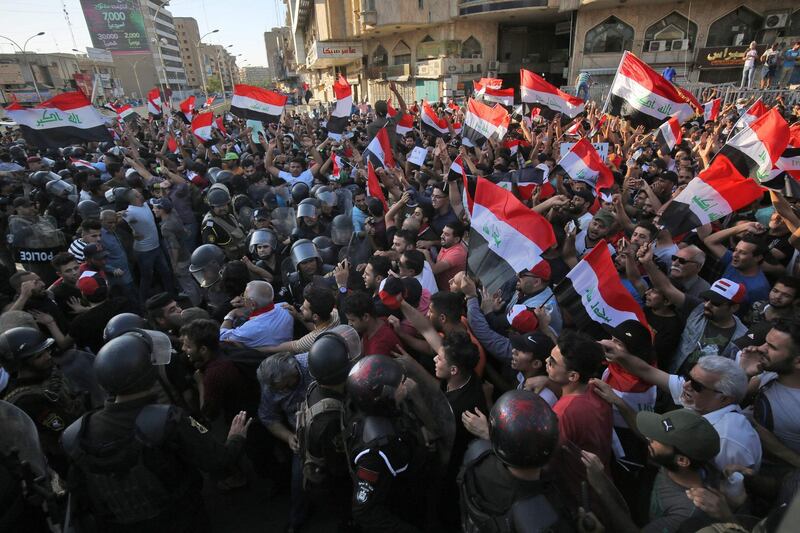 Iraqi protesters shout slogans and wave national flags in the capital Baghdad's Tahrir Square. AFP