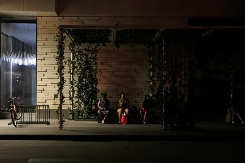 People sit outside their residential building near the Times Square area. Reuters