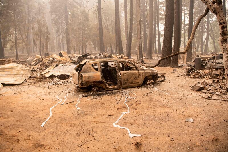 A trail of melted metal spreads away from a vehicle destroyed by the Dixie fire in Indian Falls, California.