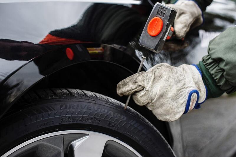 Hammering a nail into one of Bridgestone’s DriveGuard ‘run-flat’ tyres. Courtesy Aston Martin Lagonda