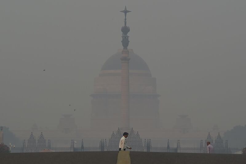 A pedestrian crosses a road near the Indian President's house. AFP