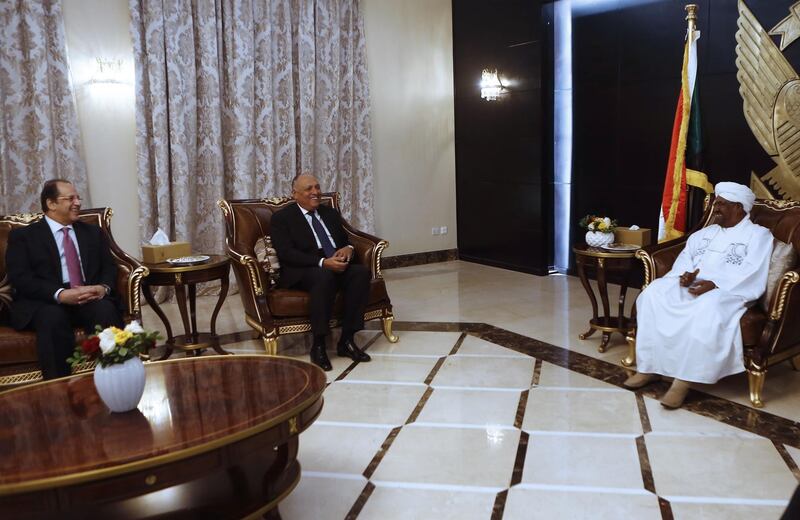 Sudanese President Omar al-Bashir (R) meets with Egyptian Foreign Minister Sameh Shukri (C) and Egyptian intelligence chief Abbas Kamel (L) in the capital Khartoum on December 27, 2018. Egypt's foreign minister and intelligence chief are in Sudan for talks with government officials facing deadly protests and calls for President Omar al-Bashir to step down over price hikes. / AFP / ASHRAF SHAZLY
