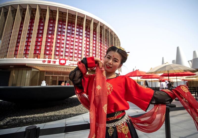 Wearing traditional costume, Keren Tang poses in front of the China pavilion. Victor Besa / The National