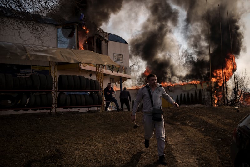 People try to recover items from a shop set on fire during a Russian attack in Kharkiv. AP