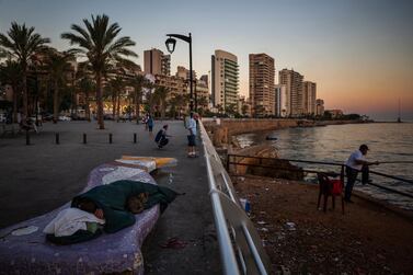 A homeless Lebanese woman and her cat sleep on a bench as the sun rises over the Mediterranean Sea in Beirut, Lebanon. AP Photo