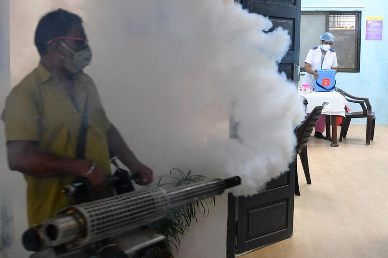 A civic authority worker fumigates a Covid-19 coronavirus vaccination centre as a preventative measure against diseases-carrying mosquitoes in Mumbai.  AFP