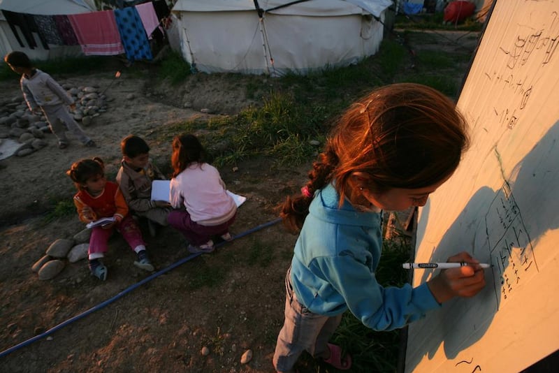 Young refugees do their homework at the Kawargosk refugee camp, 20 kilometres east of Erbil in northern Iraq, in February this year. Safin Hamed / AFP