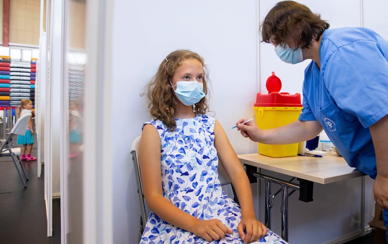 A 13-year-old girl receives a coronavirus vaccine in Estonia. AP