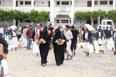 People carry food items they received from the local charity, Mona Relief, in Sanaa, Yemen, on Sunday. Reuters