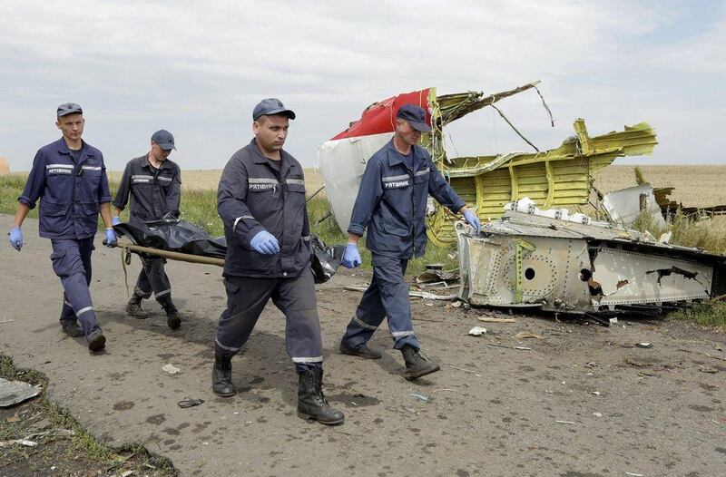 This photo from July 19, 2014, shows rescue forces carrying bodies of passengers at the MH17 crash site. Anastasia Vlasova/EPA 