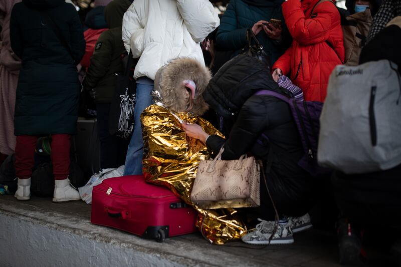 A mother tries to keep her daughter warm on the platform of Lviv railway station.