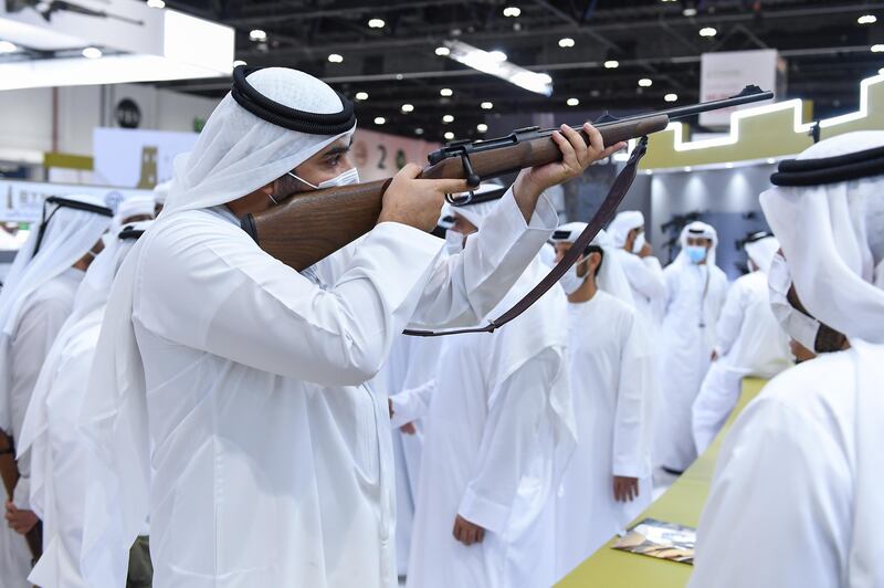 Sheikh Rashid inspects a rifle at Adihex 2021. Wam