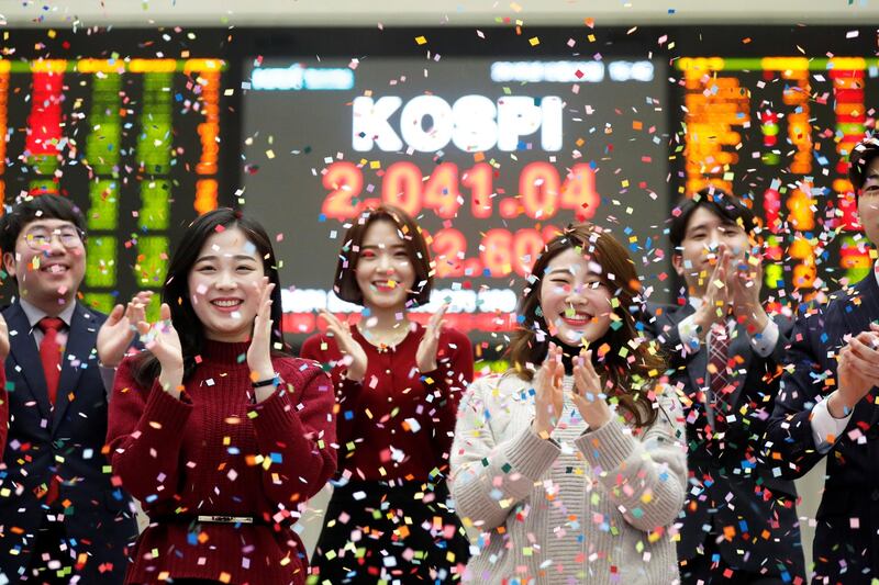Employees of the Korea Exchange (KRX) pose in front of the final stock price index during a photo opportunity for the media at the ceremonial closing event of the 2018 stock market in Seoul, South Korea. Reuters