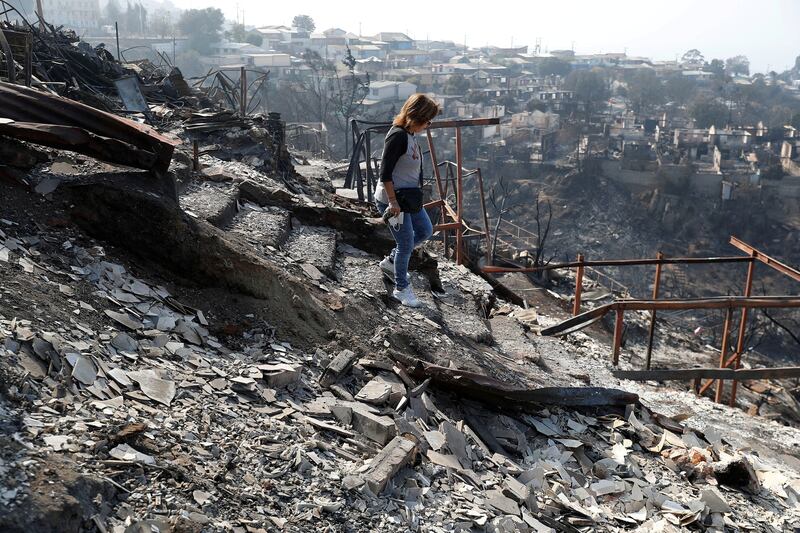 Ingrid Crespo walks on the remains of her house burned, following the spread of wildfires in Vina del Mar, Chile. Reuters