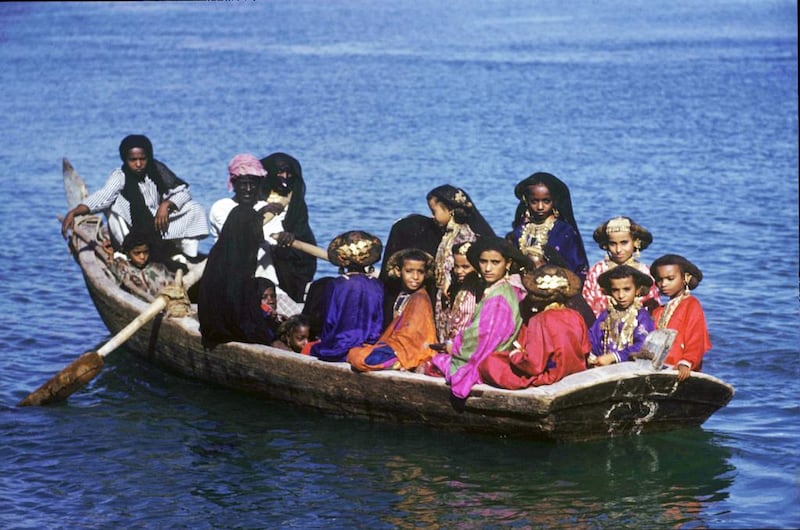 Young girls, dressed in their finery and wearing their mothers’ jewellery, cross Dubai Creek in an abra in 1953 after completing a Quranic study class. Courtesy Ronald Codrai / TCA Abu Dhabi                          