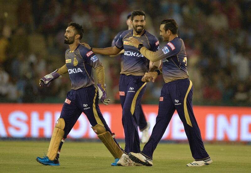 Kolkata Knight Riders team bowler Sandeep Warrier (C) celebrates with a teammate after he dismissed Kings XI Punjab cricketer Chris Gayle during the 2019 Indian Premier League (IPL) Twenty20 cricket match between Kings XI Punjab and Kolkata Knight Riders at The Punjab Cricket Association Stadium in Mohali on May 3, 2019. (Photo by Sajjad HUSSAIN / AFP) / ----IMAGE RESTRICTED TO EDITORIAL USE - STRICTLY NO COMMERCIAL USE-----