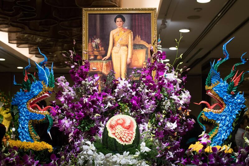 A painting depicting Thailand's Queen Sirikit adorns an elaborate fruit and vegetable decoration during a fruit and vegetable carving competition in Bangkok. Robert Schmidt / AFP