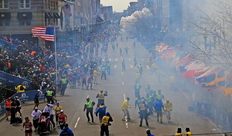 People react as an explosion goes off near the finish line of the 2013 Boston Marathon in Boston, Monday, April 15, 2013. Two explosions went off at the Boston Marathon finish line on Monday, sending authorities out on the course to carry off the injured while the stragglers were rerouted away from the smoking site of the blasts. (AP Photo/The Boston Globe, David L Ryan)  MANDATORY CREDIT *** Local Caption ***  APTOPIX Boston Marathon Explosions.JPEG-0e5e6.jpg