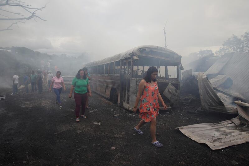 People walk in an area affected by a fuel tanker that overturned and caught fire damaging infrastructure, vehicles and houses, in Tegucigalpa, Honduras.  Reuters