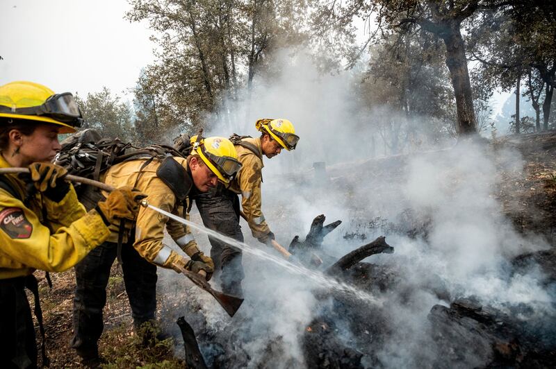 Firefighters cool down a controlled area near Yosemite National Park. AP