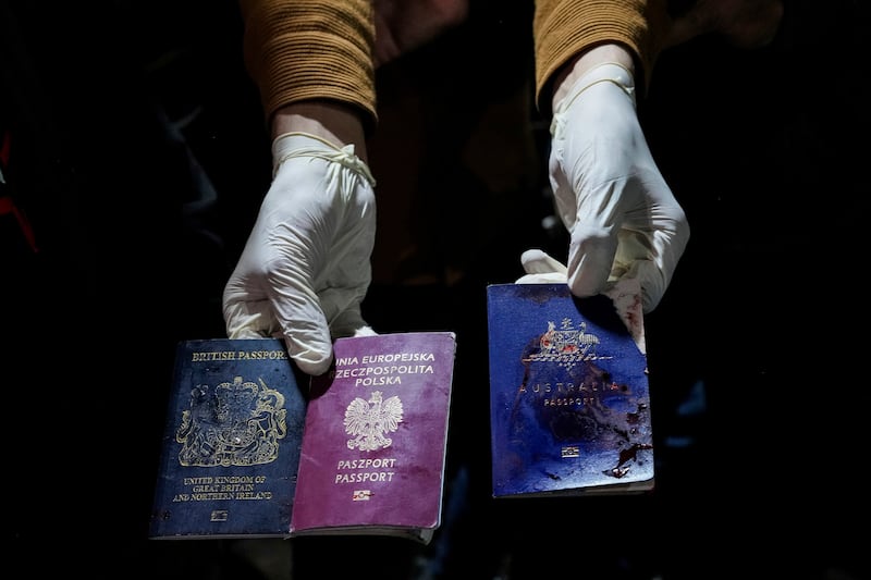 A man displays blood-stained British, Polish, and Australian passports after the Israeli air strike that killed WCK workers, including foreigners, in Deir Al Balah. AP