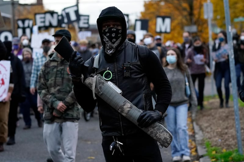 A man carries a gun as he walks during a march in support of vote counting after the Nov. 3 elections, in Portland, Oregon. AP Photo