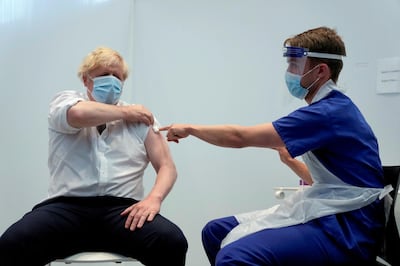 Britain's Prime Minister Boris Johnson holds up his sleeve after receiving his second dose of the AstraZeneca coronavirus disease (COVID-19) vaccine from James Black, at the Francis Crick Institute in London, Britain June 3, 2021. Matt Dunham/Pool via REUTERS