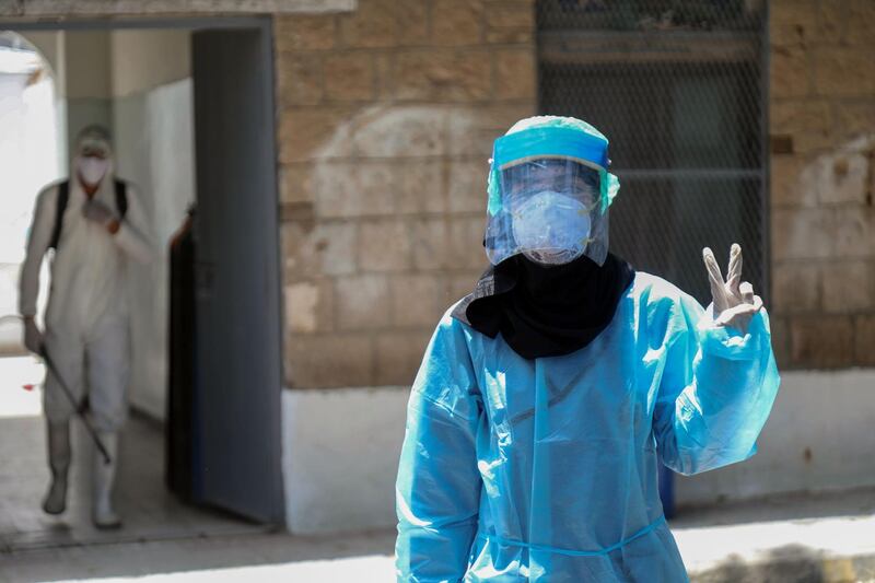 A Yemeni member of the medical staff in protective gear flashes the victory sign in the yard of a quarantine centre where Covid-19 patients are treated in Yemen's third city of Taez. AFP