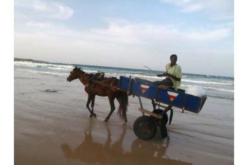 A horse and cart drives across a beach in Dakar. Scott MacMillan for The National