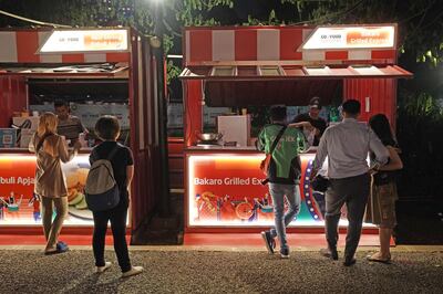 A Gojek driver, center, waits to pick an order at a Bakaro Grilled Express stall during the GoFood Festival in Jakarta, Indonesia, on Monday, July 15, 2019. Globally, the online food order industry has grown into a hyper-competitive field, which has led to consolidation as companies claw for a bigger slice of more than $300 billion in restaurant deliveries. Photographer: Dimas Ardian/Bloomberg