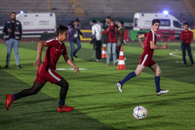 A child representing Qatar advances up the pitch