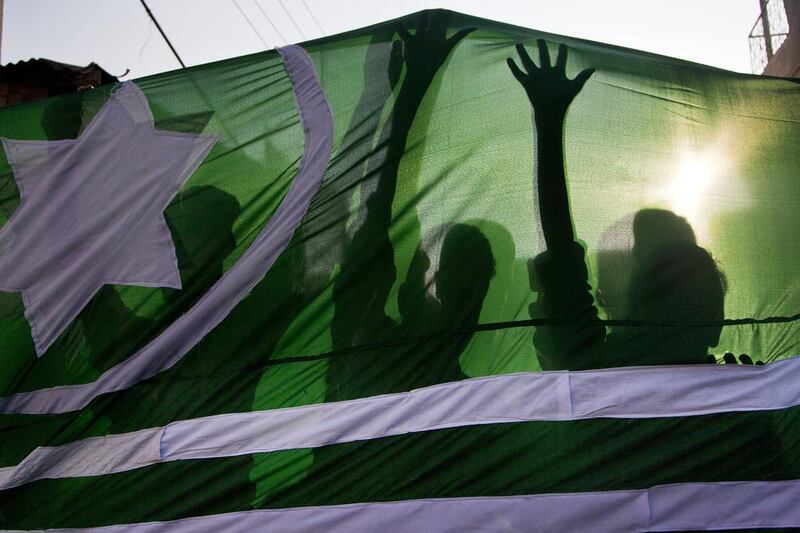 Shadows of Kashmiri protesters are cast on a Pakistan occupied Kashmir flag as they shout slogans during a protest in Srinagar.  Dar Yasin / AP Photo