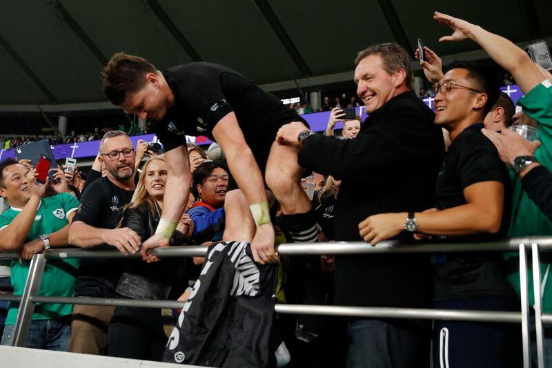 New Zealand's full back Beauden Barrett collects an All Blacks flag from the crowd beside his father Kevin (2nd R) after winning the Japan 2019 Rugby World Cup quarter-final match between New Zealand and Ireland at the Tokyo Stadium in Tokyo. AFP