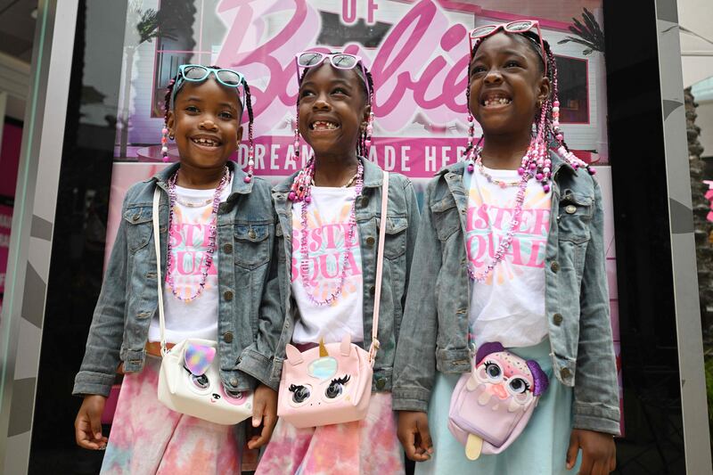 Seven-year-old triplets Taylor, left, Kristin, centre, and Morgan Seals celebrate their birthday by visiting The World of Barbie