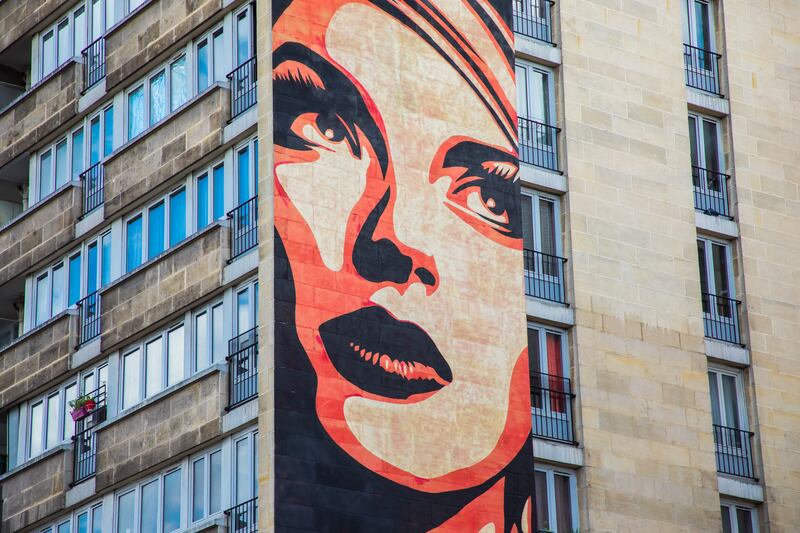 Rise Above Rebel by American artist Shepard Fairey is displayed on a building in Paris. EPA