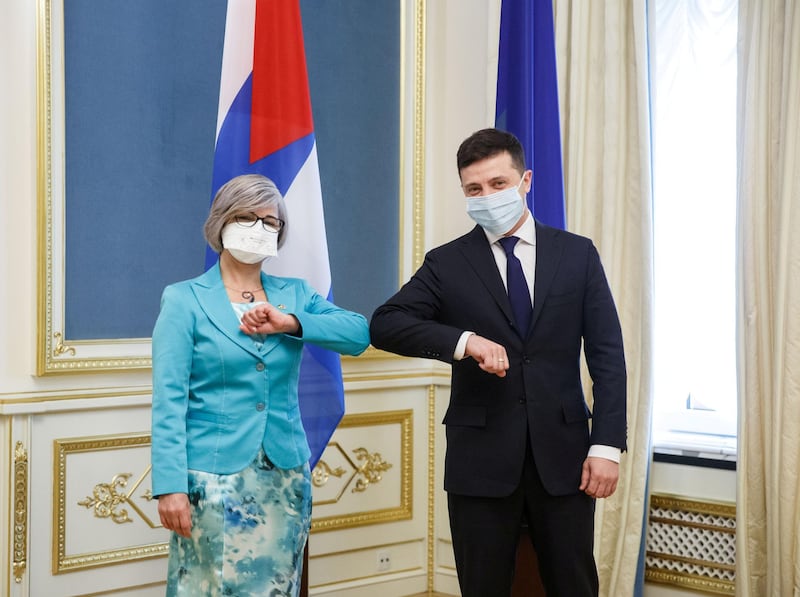 Ukraine's President Volodymyr Zelenskiy and Cuba's Ambassador Natacha Diaz Aguilera pose for a picture while greeting each other with an elbow bump instead of a traditional handshake during a ceremony to receive diplomatic credentials amid the coronavirus disease (COVID-19) outbreak in Kiev, Ukraine. REUTERS