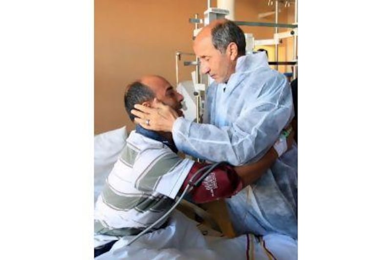Chairman of the Libyan National Transitional Council Mustafa Abdel Jalil visits a fighter, wounded during fighting in Sirte, in Benghazi Medical Centre on Saturday.